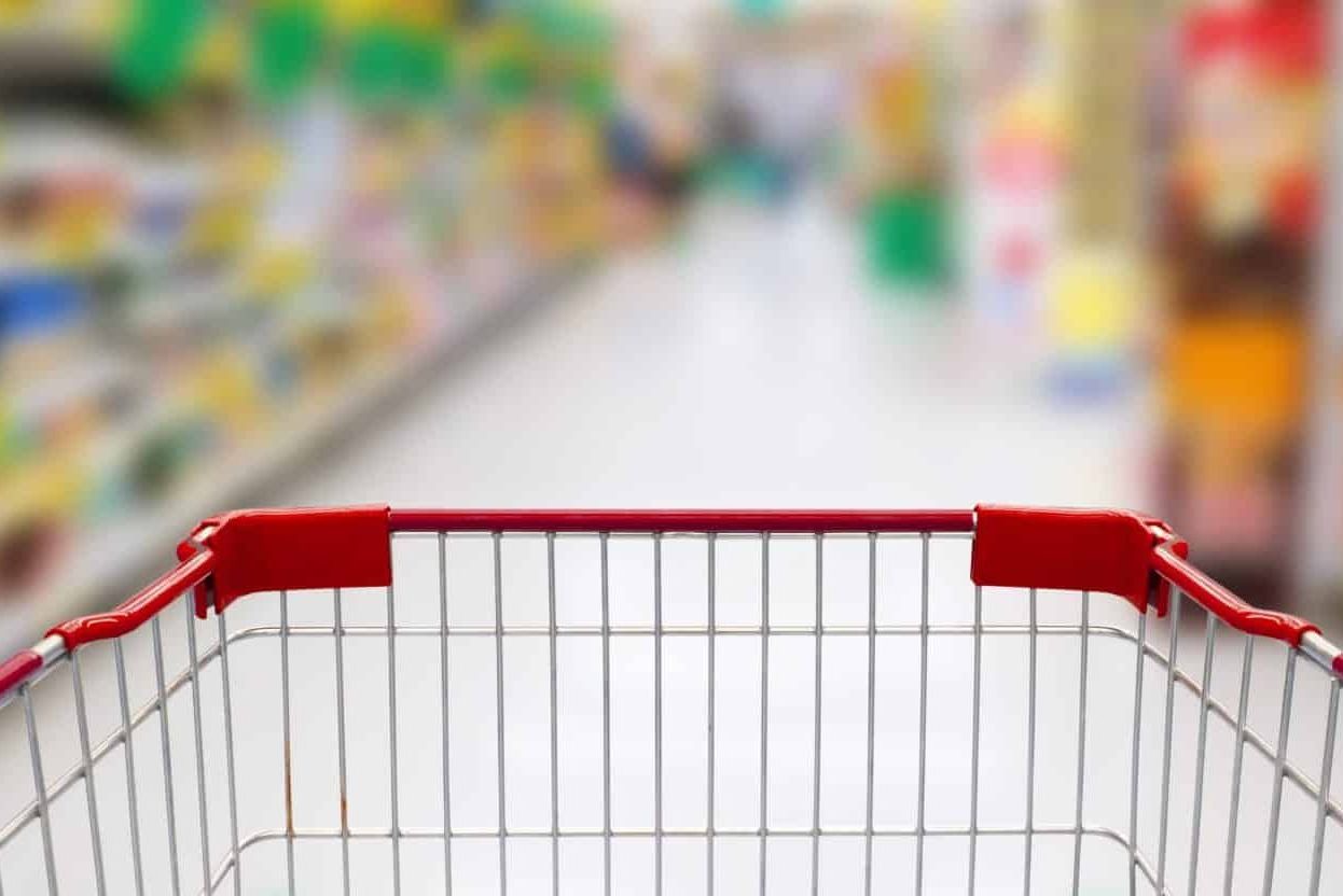 supermarket aisle with empty red shopping cart